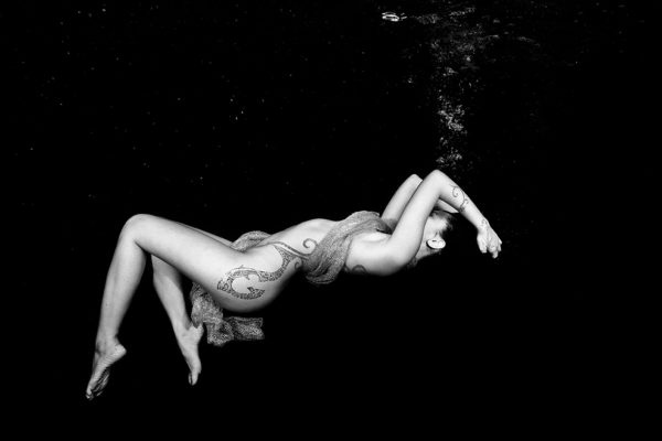Photographie noir et blanc de sirène tatouée, artiste Christian Coulombe, spécialisé en mermaid underwater photography.