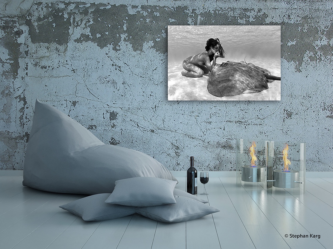 Photographie noir et blanc sous marine, rencontre sur un fond sablonneux entre une vahine et une raie, de l'artiste photographe Christian Coulombe, spécialisé en mermaid underwater photography.